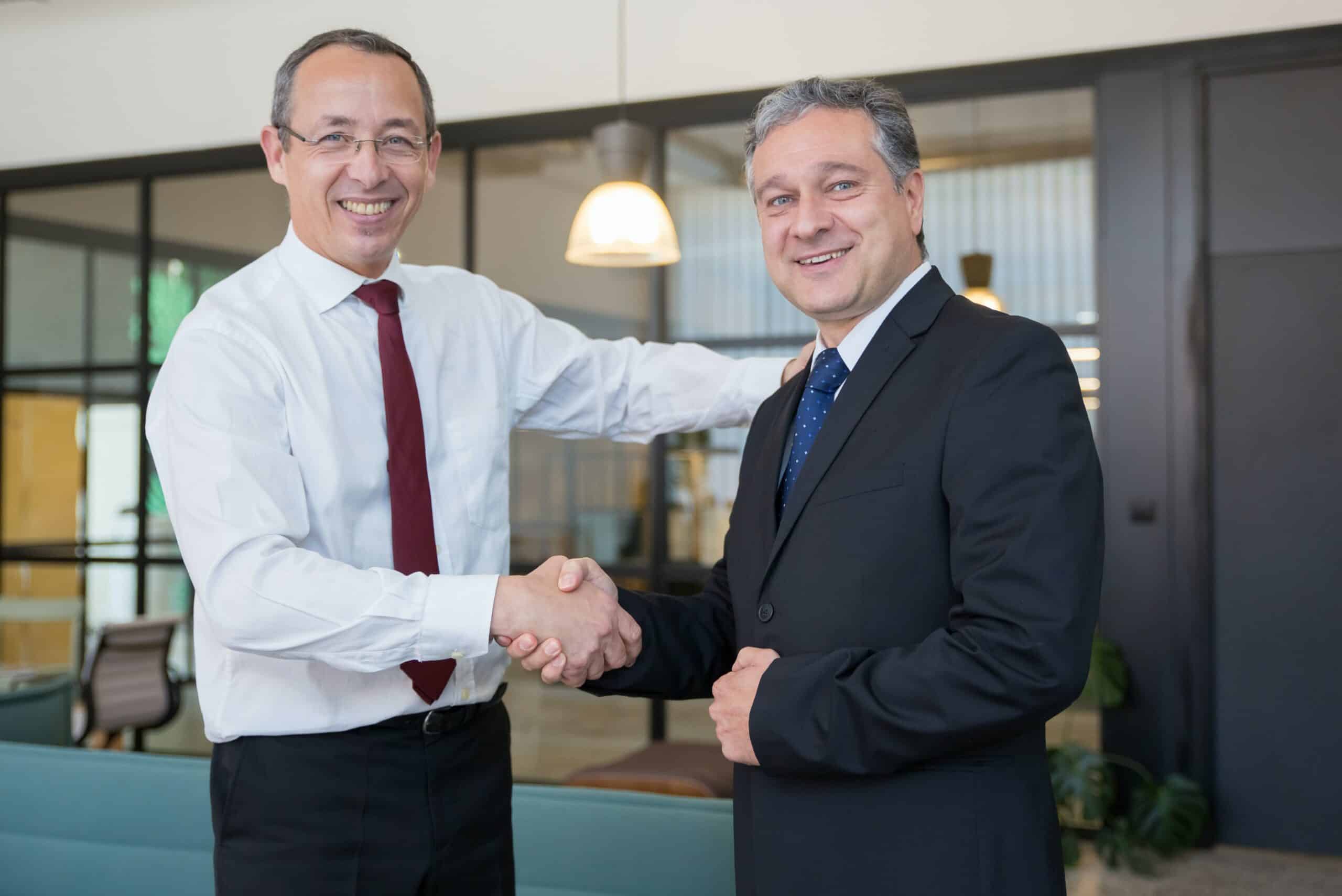 Two businessmen shaking hands as part of a 'refer a friend' campaign