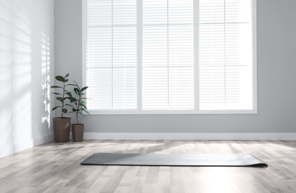 Unrolled Grey Yoga Mat On Floor In Room
